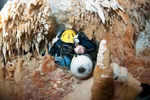 Brian Kakuk sliding through a restriction in the Badlands of Dan's Cave. Photo by Jill Heinerth